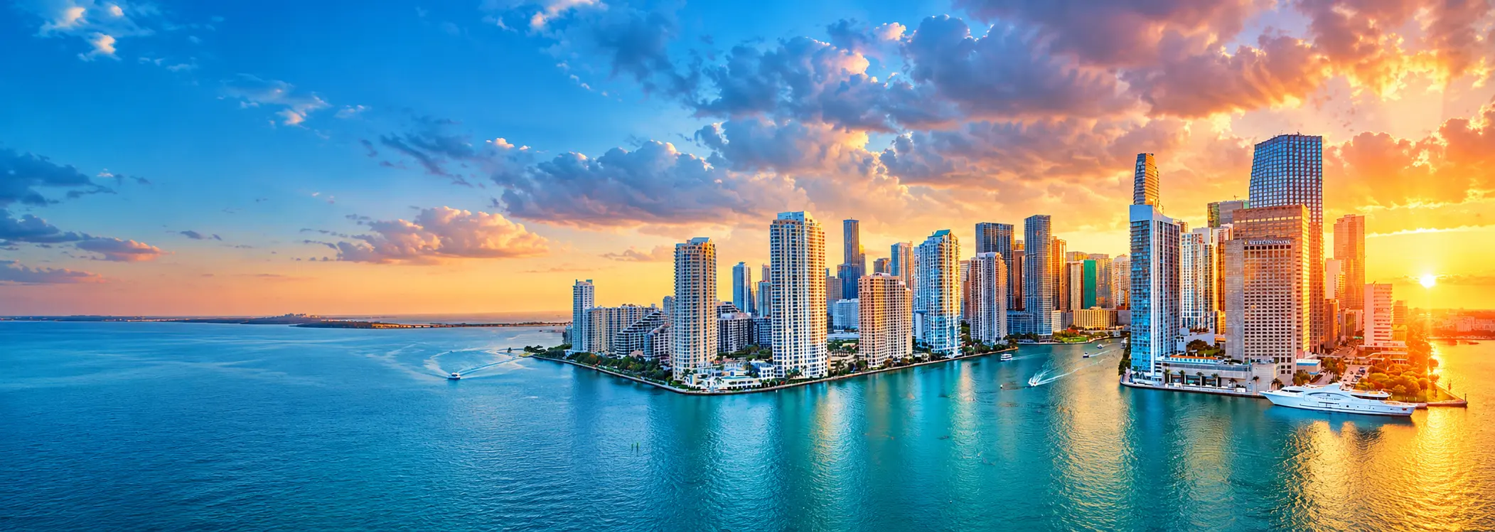 Miami skyline at sunset reflected across the bay